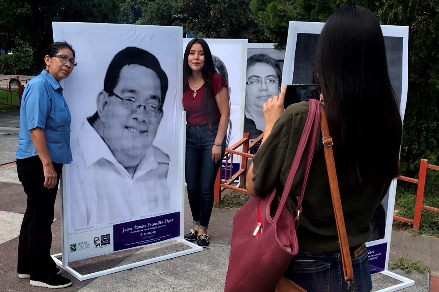 Rosario Sánchez se toma una foto con el retrato de su esposo Jaime Escamilla, un promotor de salud de Olocuilta (La Paz), quien falleció de Covid-19 el 7 de febrero de 2021. La acompañan sus hijas Gabriela y Jacir Escamilla. Jaime, de 57 años, mostró síntomas el 27 de enero, y fue llevado a un hospital, donde falleció. "Me avisaron que lo fuéramos a traer. Eso es lo más triste, ya no verlo", dijo Rosario. Foto de El Faro: Nelson Rauda.